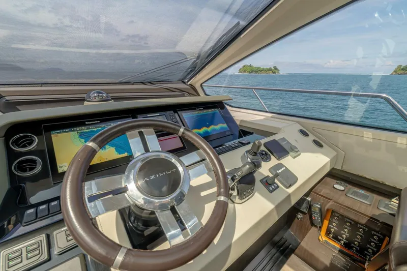 Carpe Diem Yacht Photos Pics Cockpit of 2017 Azimut 77S yacht with navigation screens and steering wheel, overlooking the ocean.