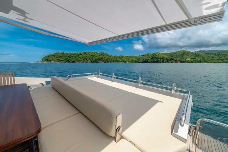 Carpe Diem Yacht Photos Pics Luxurious 2017 Azimut 77S yacht deck with ocean view and lush green island backdrop.