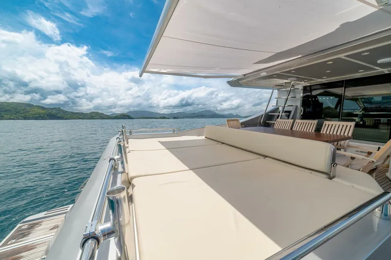 Carpe Diem Yacht Photos Pics Luxurious 2017 Azimut 77S yacht deck with sunbed, dining area, and scenic ocean view.
