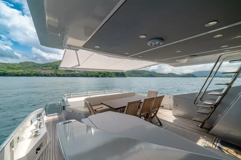 Carpe Diem Yacht Photos Pics Luxurious 2017 Azimut 77S yacht deck with dining area, overlooking serene waters and lush hills.