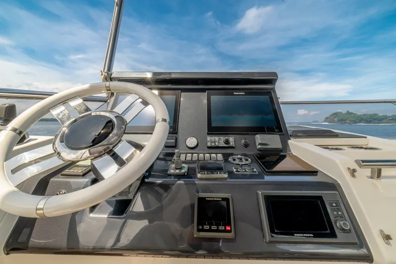 Carpe Diem Yacht Photos Pics Steering wheel and control panel of 2017 Azimut 77S yacht under clear blue sky.