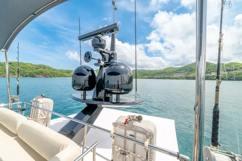 Carpe Diem Yacht Photos Pics Luxurious 2017 Azimut 77S yacht with fishing rods, scenic ocean view, and lush green hills.