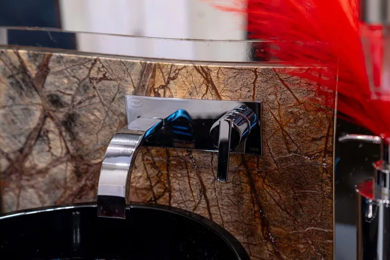 Carpe Diem Yacht Photos Pics Luxurious bathroom faucet on Azimut 77S yacht, 2017 model, with elegant stone backdrop.