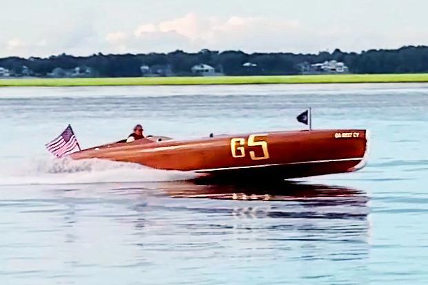 Custom 2024 Treworgy Replica of 30’ Baby Bootlegger speedboat on water, American flag displayed.