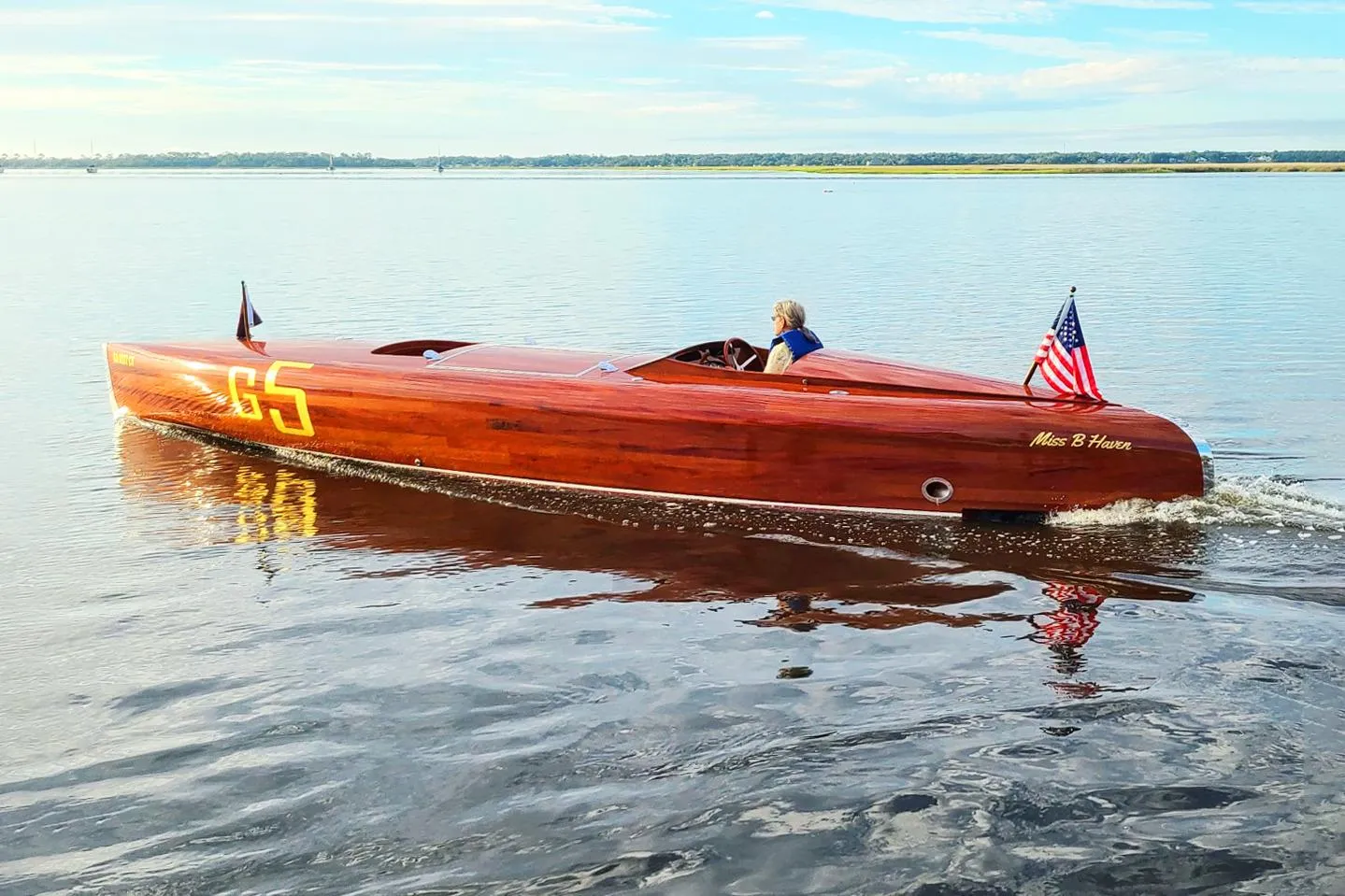Custom 2024 Treworgy Replica of 30’ Baby Bootlegger on calm water, American flag displayed.