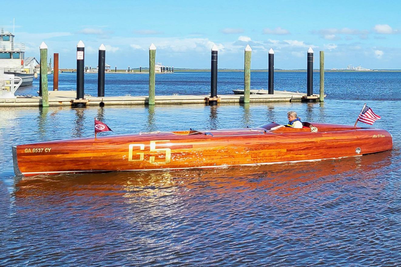 2024 Treworgy Replica of 30’ Baby Bootlegger boat on water, American flag displayed.