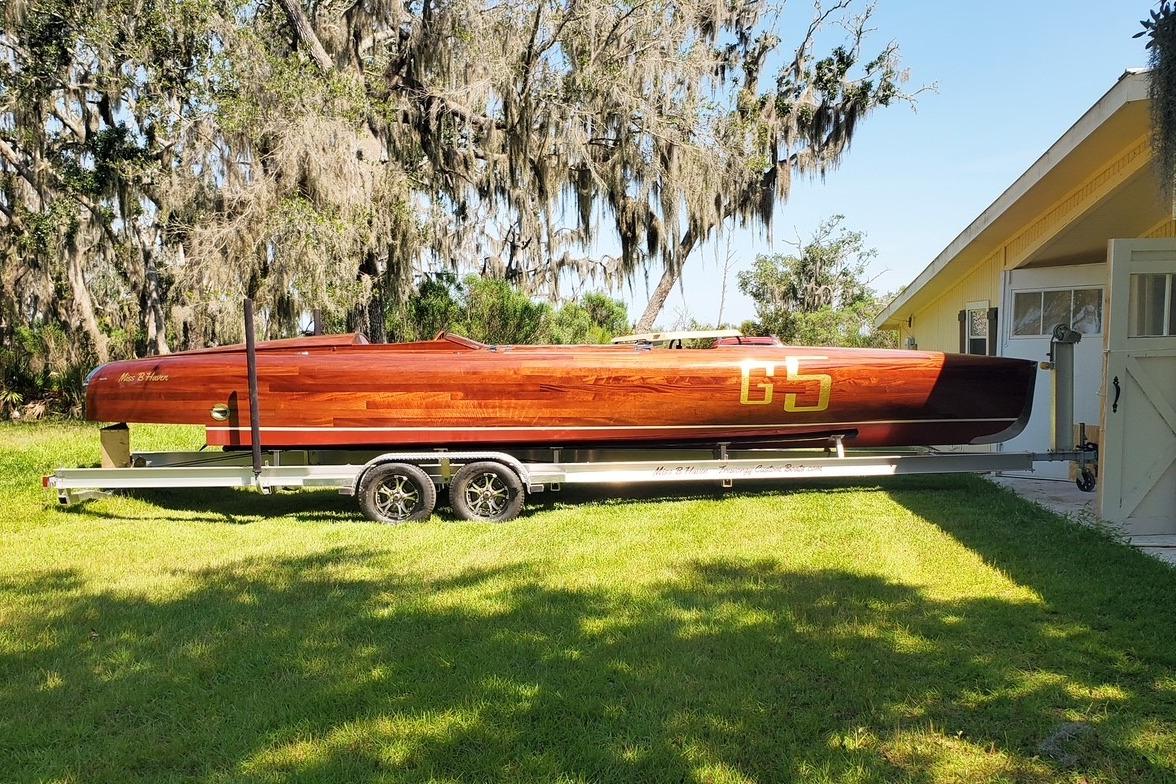 2024 Custom Treworgy Replica of 30’ Baby Bootlegger on trailer, parked in sunny yard.