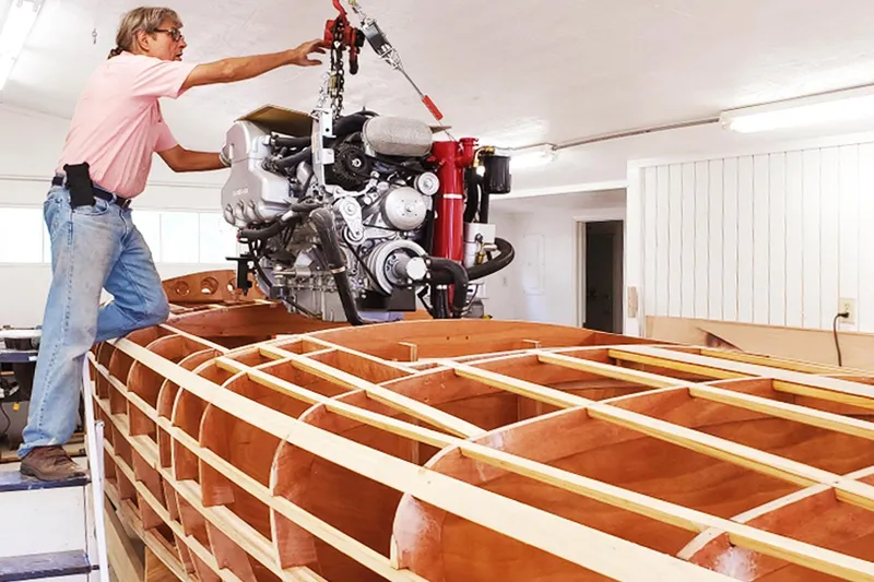  Yacht Photos Pics Man installing engine in 2024 Treworgy Replica of 30’ Baby Bootlegger boat.