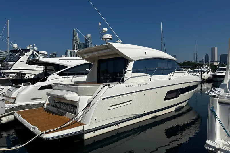 Seas The Day Yacht Photos Pics Luxury 2018 Prestige 460 yacht docked in marina, city skyline in background.