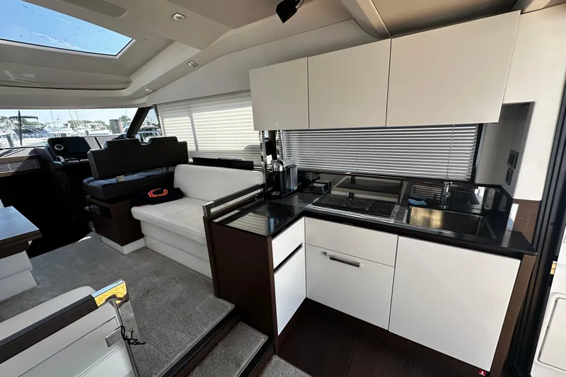 Seas The Day Yacht Photos Pics Luxurious interior of a 2018 Prestige 460 yacht featuring a modern kitchen and seating area.