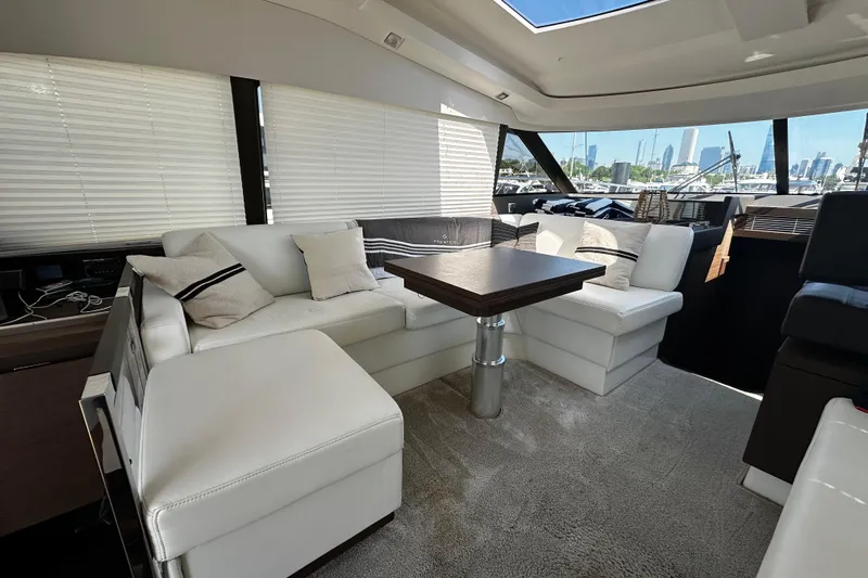 Seas The Day Yacht Photos Pics Luxurious interior of a 2018 Prestige 460 yacht with white seating and a wooden table.