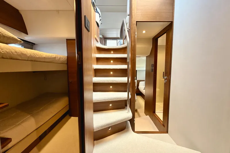  Yacht Photos Pics Luxurious interior of 2026 Princess F50 yacht with elegant staircase and cozy cabin.