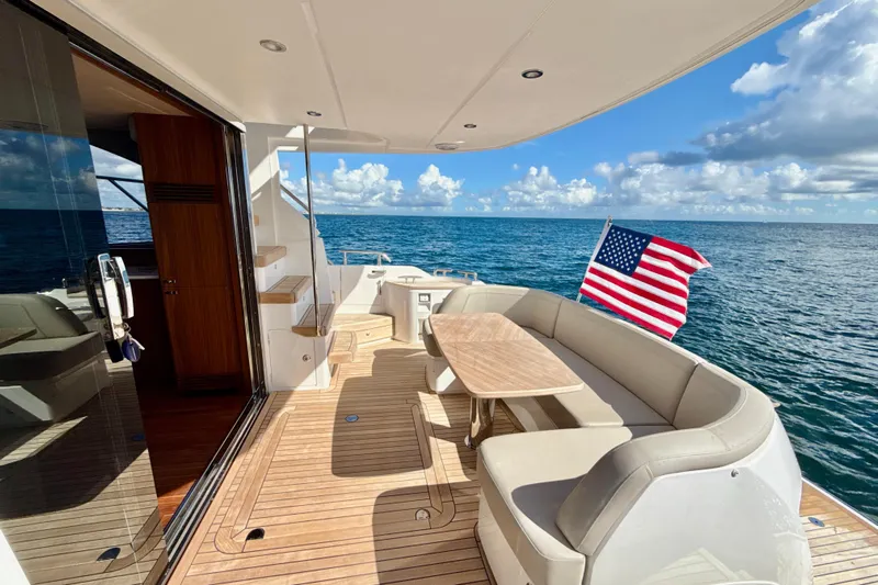  Yacht Photos Pics Luxurious 2026 Princess F50 yacht deck with American flag, ocean view, and elegant seating area.