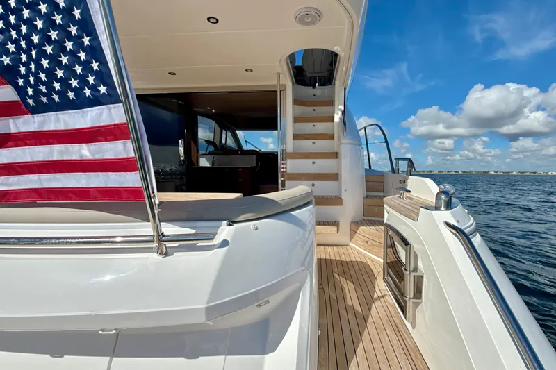  Yacht Photos Pics Luxurious 2026 Princess F50 yacht deck with American flag, ocean view, and clear blue sky.