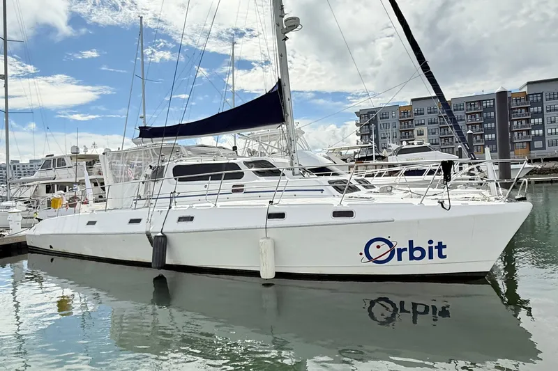 Orbit Yacht Photos Pics 2011 Royal Cape Catamarans Majestic 53 catamaran docked in a marina, named "Orbit."