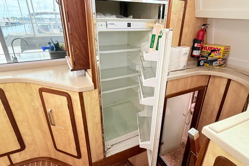 Orbit Yacht Photos Pics Interior of 2011 Royal Cape Catamarans Majestic 53 with open fridge and wooden cabinetry.