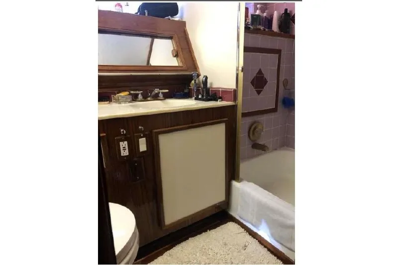 Top Coat Yacht Photos Pics 1974 Pacemaker Cockpit Motoryacht bathroom with wooden vanity, mirror, and bathtub.