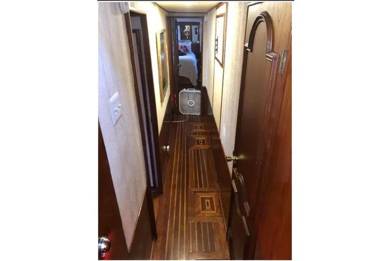 Top Coat Yacht Photos Pics Narrow hallway inside a 1974 Pacemaker Cockpit Motoryacht with wooden flooring and doors.