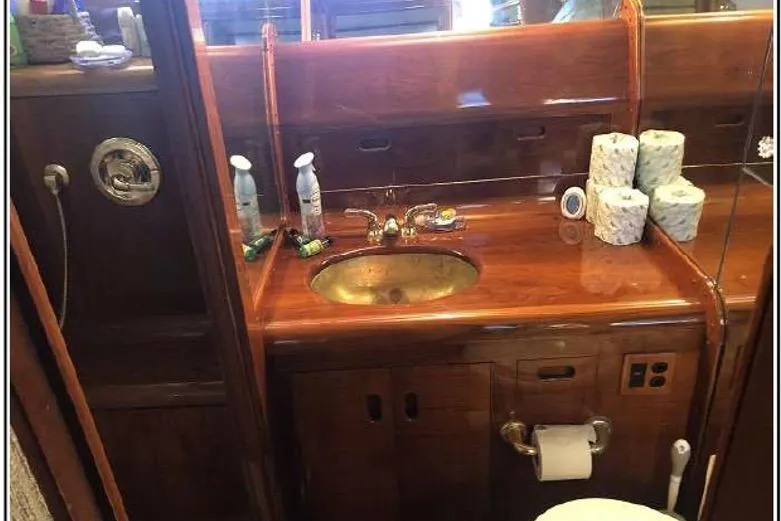 Top Coat Yacht Photos Pics Luxurious wooden bathroom interior on 1974 Pacemaker Cockpit Motoryacht with brass sink and toiletries.