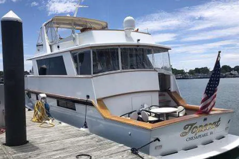 Top Coat Yacht Photos Pics 1974 Pacemaker Cockpit Motoryacht docked, featuring American flag and outdoor seating.