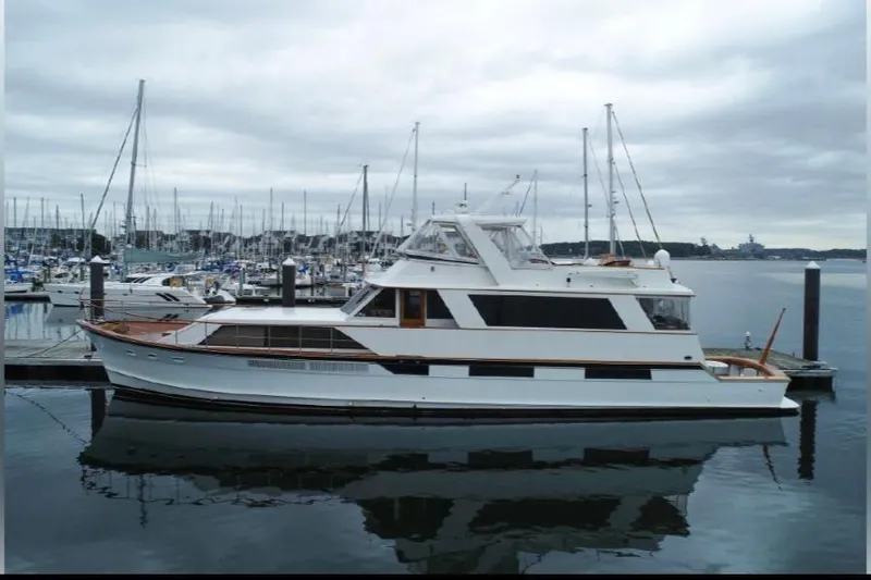 Top Coat Yacht Photos Pics 1974 Pacemaker Cockpit Motoryacht docked in a marina under cloudy skies.