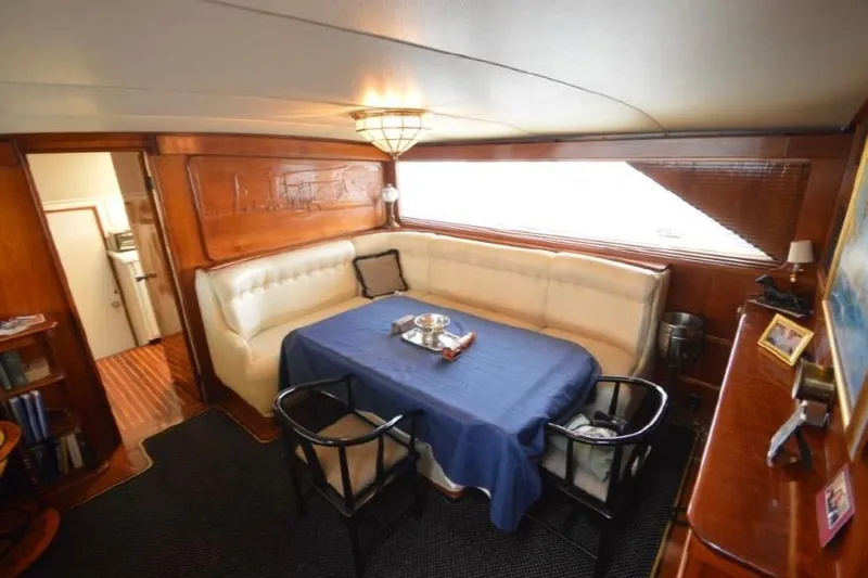Top Coat Yacht Photos Pics Interior of 1974 Pacemaker Cockpit Motoryacht with dining area and blue tablecloth.