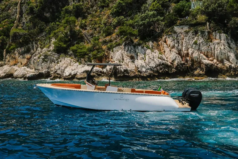  Yacht Photos Pics 2025 Lilybaeum Levanzo 25 Lounge Deck boat cruising near rocky coastline.
