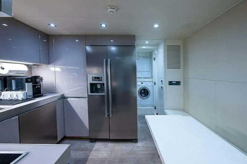 Coal Blooded Yacht Photos Pics Modern kitchen and laundry area inside a 2014 Pershing 92 yacht.