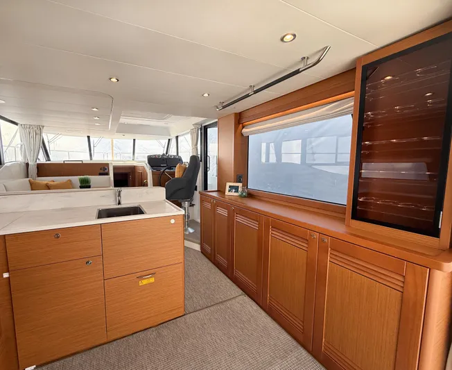 Demo Yacht Photos Pics Interior of 2025 Beneteau Swift Trawler 48, featuring modern kitchen and elegant wood cabinetry.