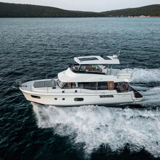 Demo Yacht Photos Pics 2025 Beneteau Swift Trawler 48 cruising on open water, side view.