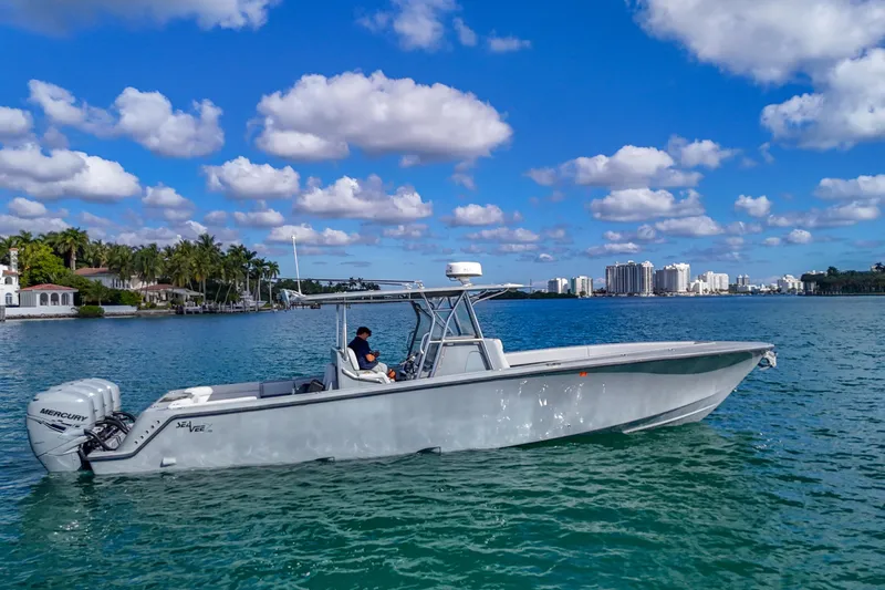  Yacht Photos Pics 2018 SeaVee 390Z boat cruising on a sunny day with city skyline in background.