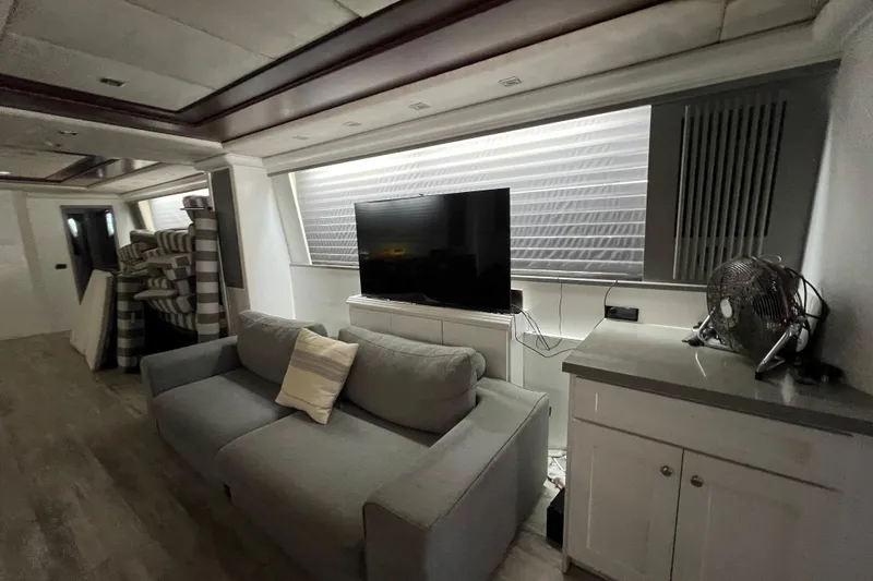 M/y Q Yacht Photos Pics Luxurious Falcon 106 yacht interior, featuring a modern living area with a sofa and TV, 2001 model.