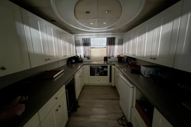 M/y Q Yacht Photos Pics Luxurious yacht kitchen with white cabinets, modern appliances, and sleek countertops, Falcon 106, 2001.