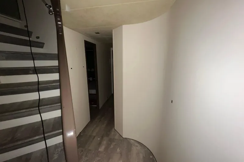 M/y Q Yacht Photos Pics Narrow hallway with curved walls and stairs in Falcon 106, 2001 model.