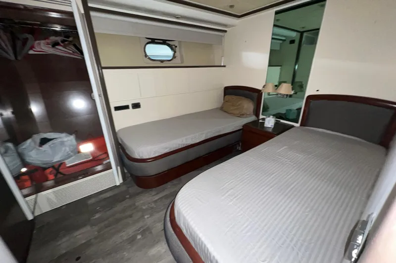 M/y Q Yacht Photos Pics Interior of a 2001 Falcon 106 yacht cabin with twin beds and a small window.