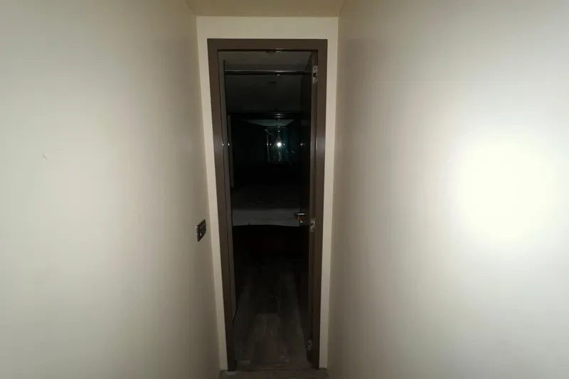 M/y Q Yacht Photos Pics Narrow hallway leading to a dimly lit room in a 2001 Falcon 106 vehicle.