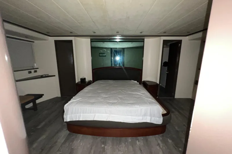 M/y Q Yacht Photos Pics Luxurious bedroom interior on Falcon 106 yacht, 2001 model, featuring a large bed and modern design.