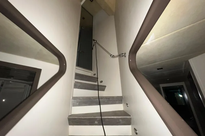 M/y Q Yacht Photos Pics Staircase inside 2001 Falcon 106 yacht, featuring modern design and sleek handrails.