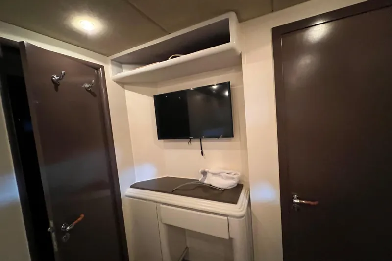 M/y Q Yacht Photos Pics Interior of Falcon 106 yacht, featuring a wall-mounted TV and storage area, 2001 model.