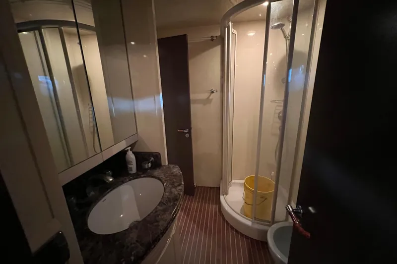 M/y Q Yacht Photos Pics Compact bathroom in 2001 Falcon 106 yacht with shower and marble countertop.