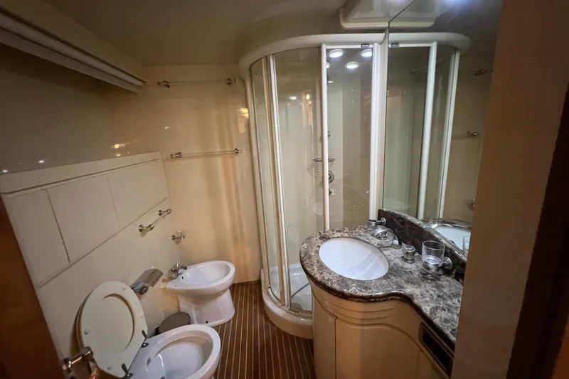 M/y Q Yacht Photos Pics Luxurious bathroom in 2001 Falcon 106 yacht with shower, toilet, and marble sink.