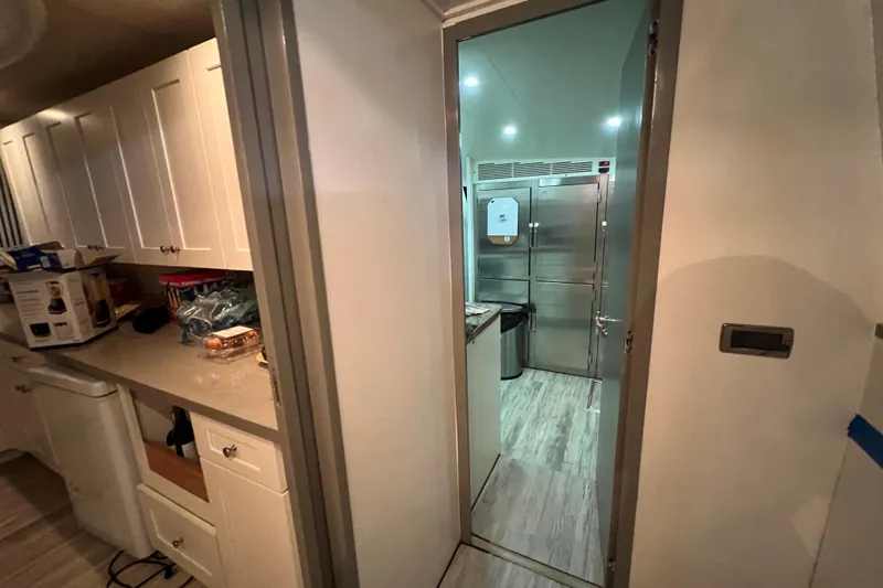 M/y Q Yacht Photos Pics Modern kitchen interior in a 2001 Falcon 106, featuring white cabinets and stainless steel appliances.