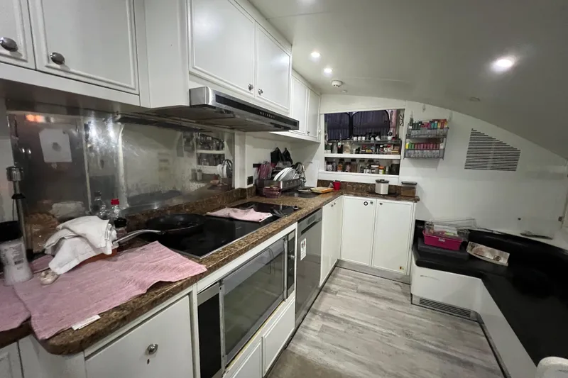 M/y Q Yacht Photos Pics Compact kitchen interior on a 2001 Falcon 106 yacht, featuring modern appliances and storage.