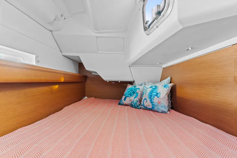 Deep Blue Yacht Photos Pics Cozy cabin interior of 2020 Jeanneau Sun Odyssey 389 with decorative pillows and wooden accents.