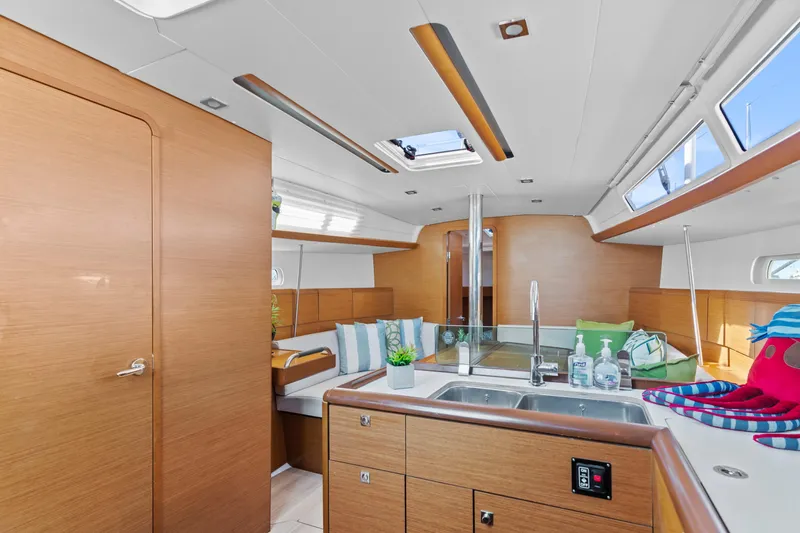 Deep Blue Yacht Photos Pics Interior of 2020 Jeanneau Sun Odyssey 389 sailboat, featuring modern kitchen and seating area.