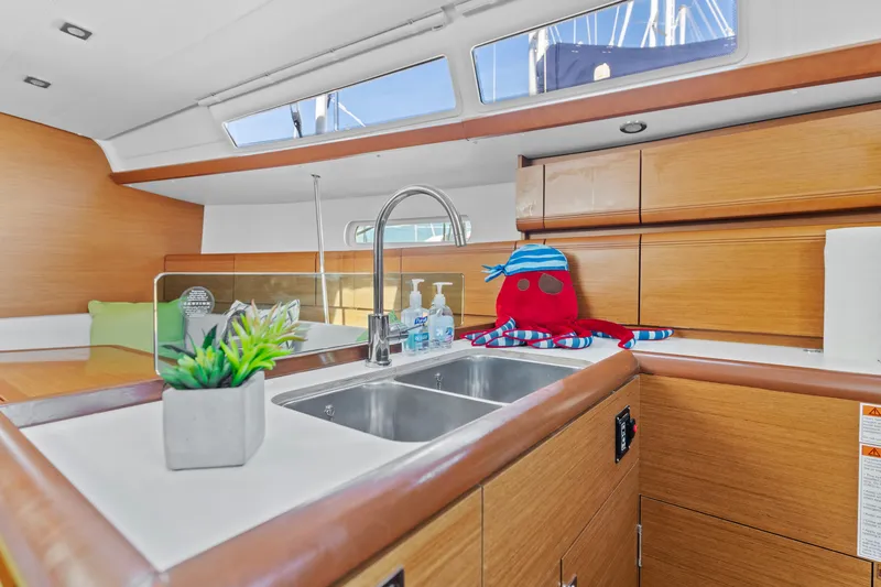 Deep Blue Yacht Photos Pics Modern kitchen interior of 2020 Jeanneau Sun Odyssey 389 yacht with wooden cabinets and decor.