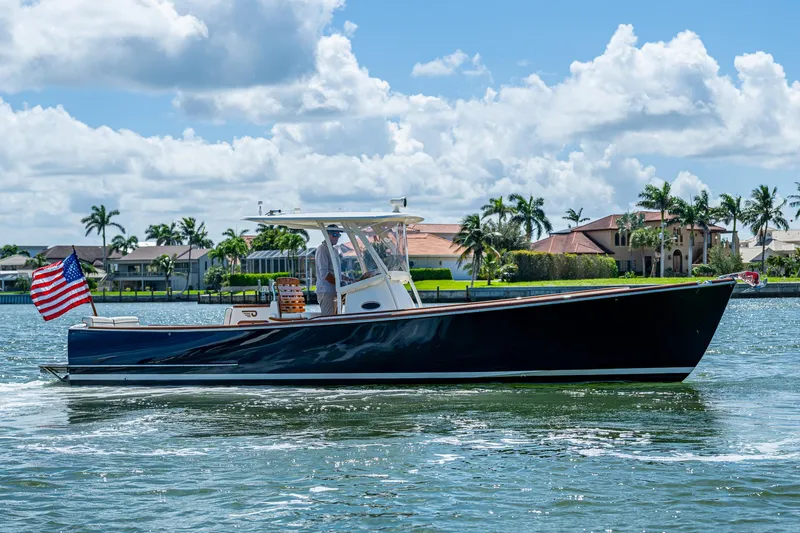 Summer Wind Yacht Photos Pics 2003 Hinckley Talaria 29 Center Console boat cruising on a sunny day, American flag displayed.