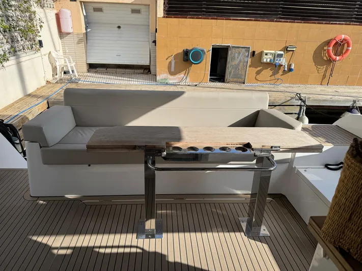 Sealine C530 Yacht Photos Pics Sealine C530 2017 yacht deck with seating and table, docked at marina.