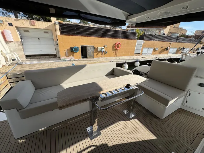 Sealine C530 Yacht Photos Pics 2017 Sealine C530 yacht deck with seating and table, docked at marina.