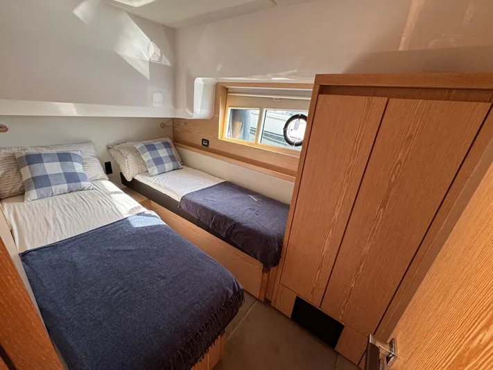 Sealine C530 Yacht Photos Pics Twin cabin interior of 2017 Sealine C530 yacht with wooden finishes and cozy bedding.